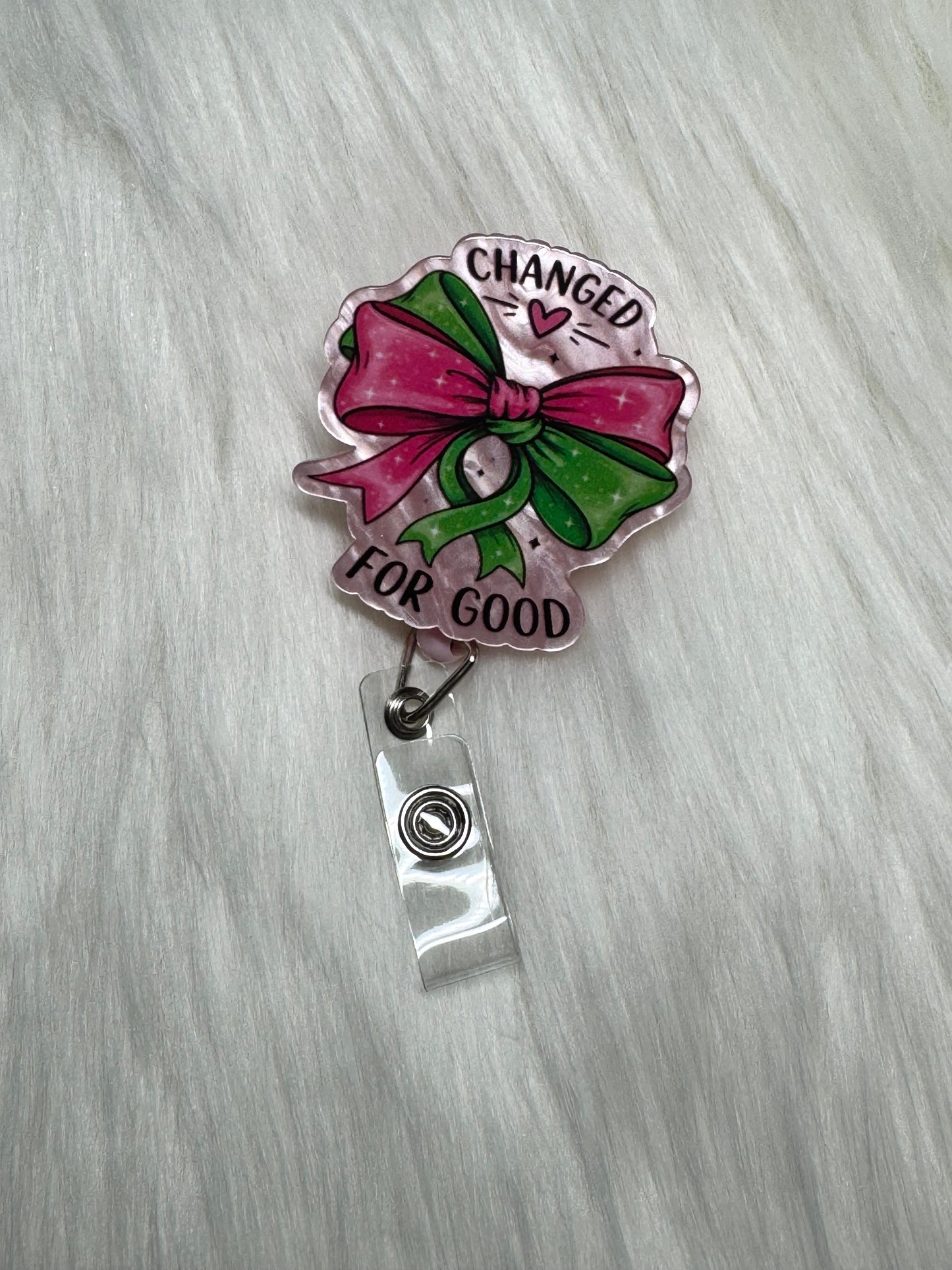 đ âChanged for Goodâ Glitter Bow Badge Reel